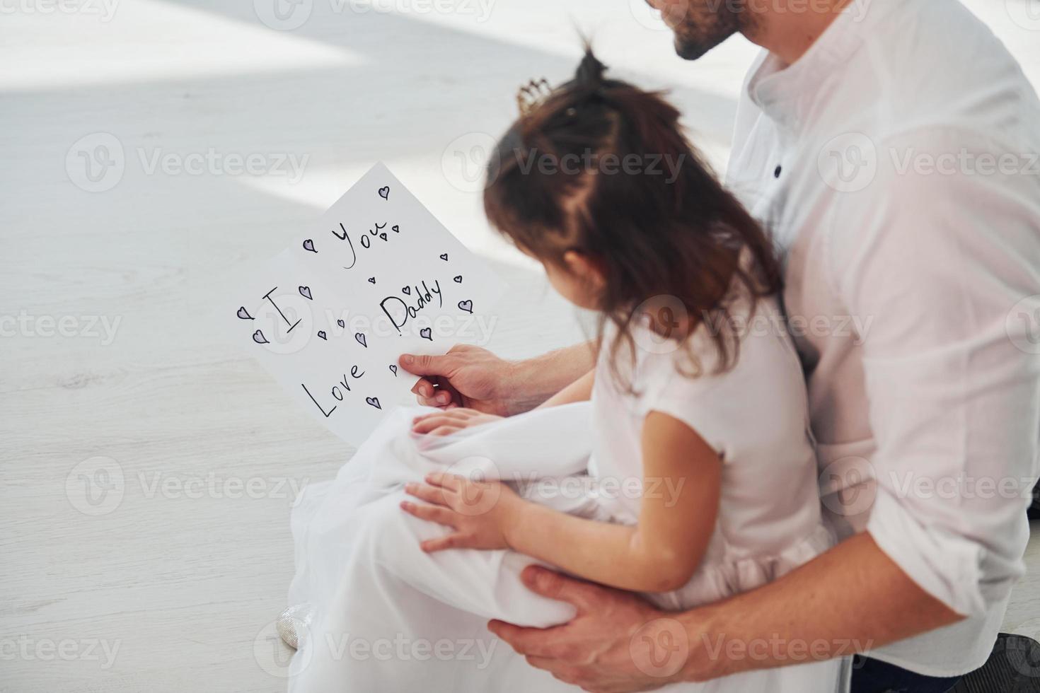 Alles gute zum Vatertag. Tochter überrascht Papa, indem sie Postkarte mit Herz gibt foto