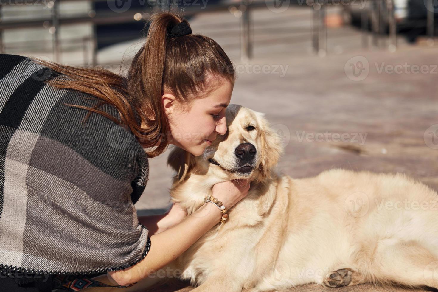 Junge positive Frau hat Spaß mit ihrem Hund, wenn sie im Freien spazieren geht foto
