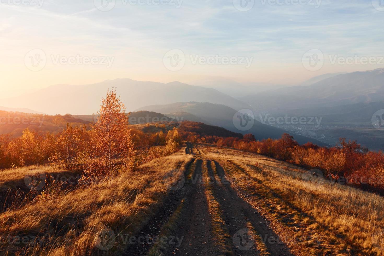 majestätische Landschaft mit Herbstbäumen und Bergen am Horizont foto