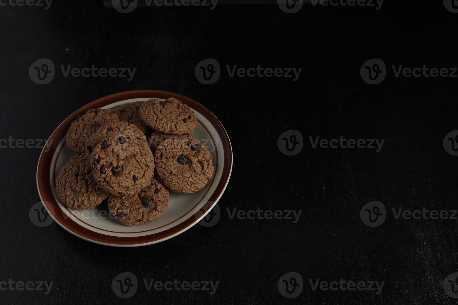 Chocolate Chip Cookies auf Platte auf schwarzem Hintergrund foto
