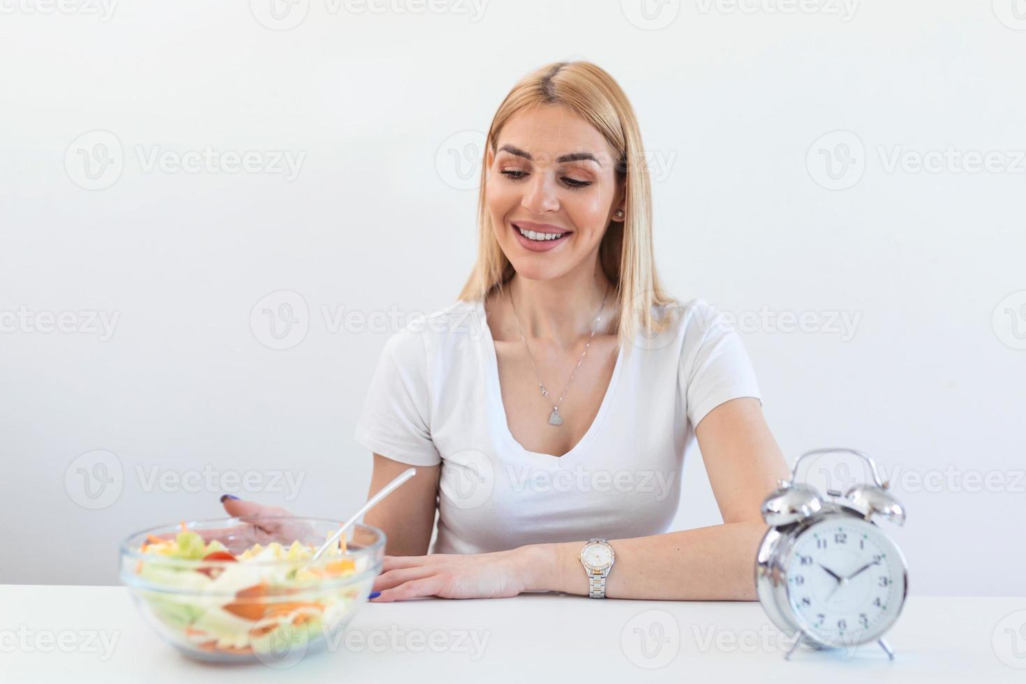 Zeit zum Abnehmen, Essenskontrolle oder Zeit zum Diätkonzept. retro-wecker, in dem frau intermittierendes fasten mit einem gesunden salatessen macht. foto