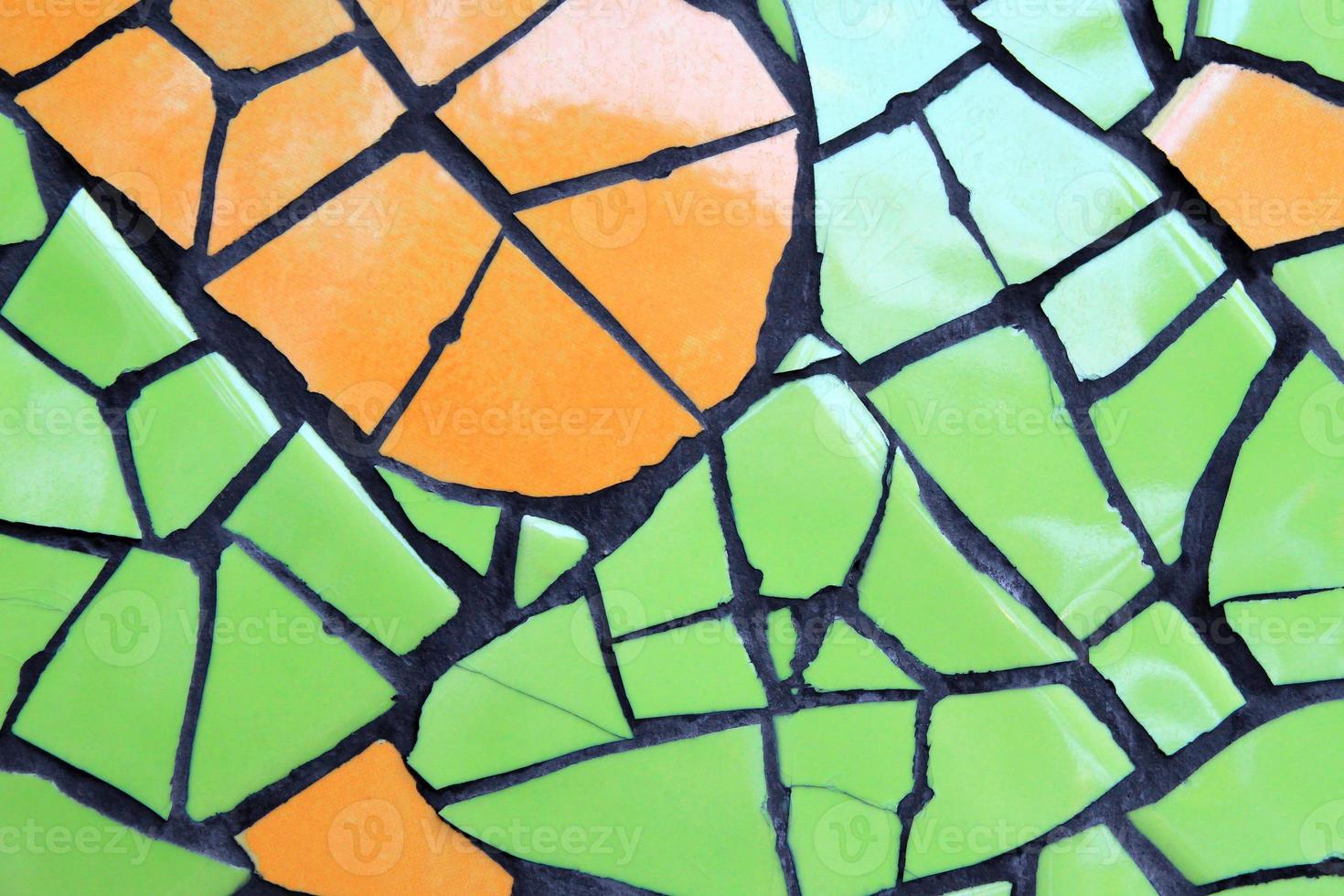 eine Wand aus Keramikstücken in grüner und oranger Farbe für den Hintergrund. foto
