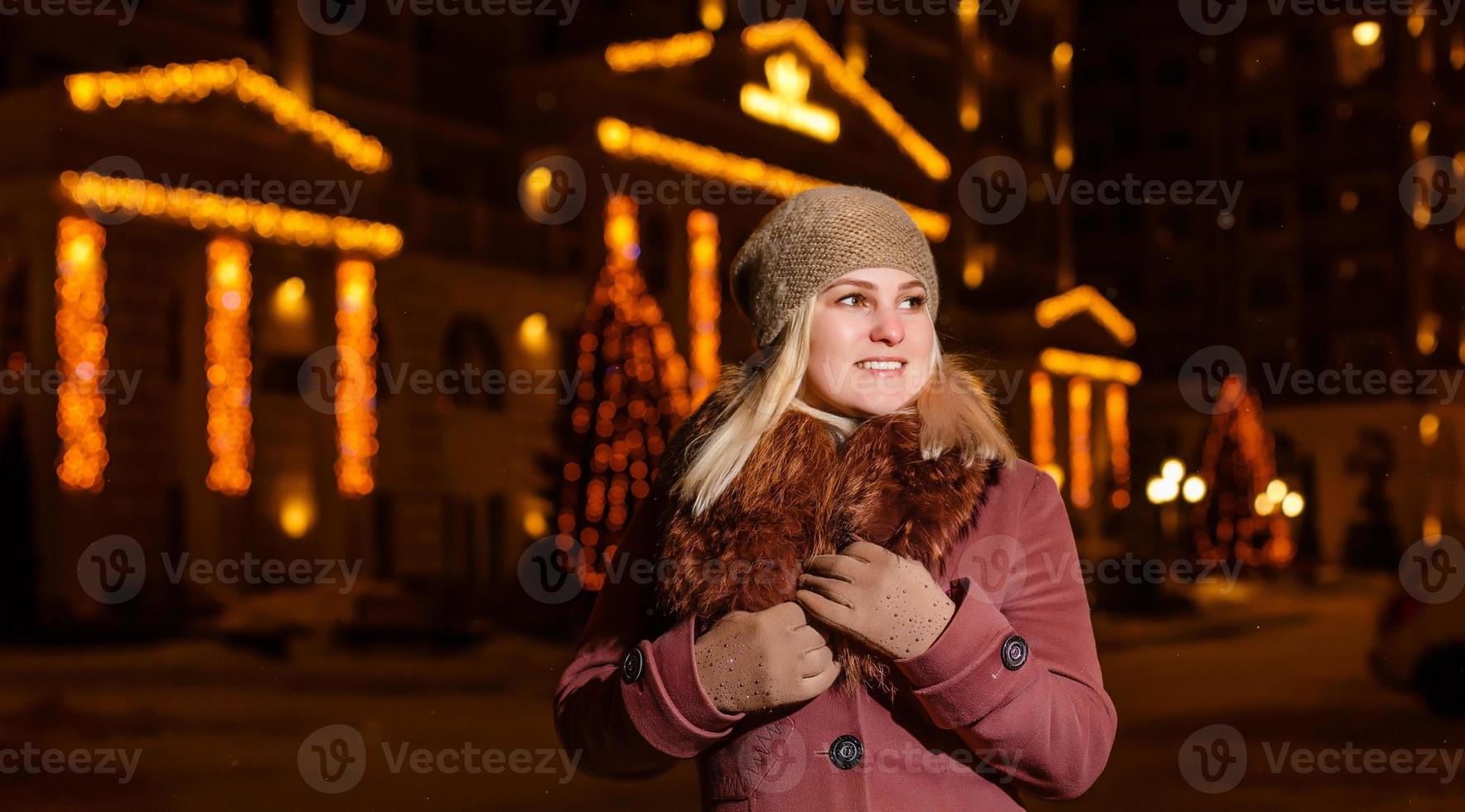 lächelnde Winterfrau in der Nachtstadt foto