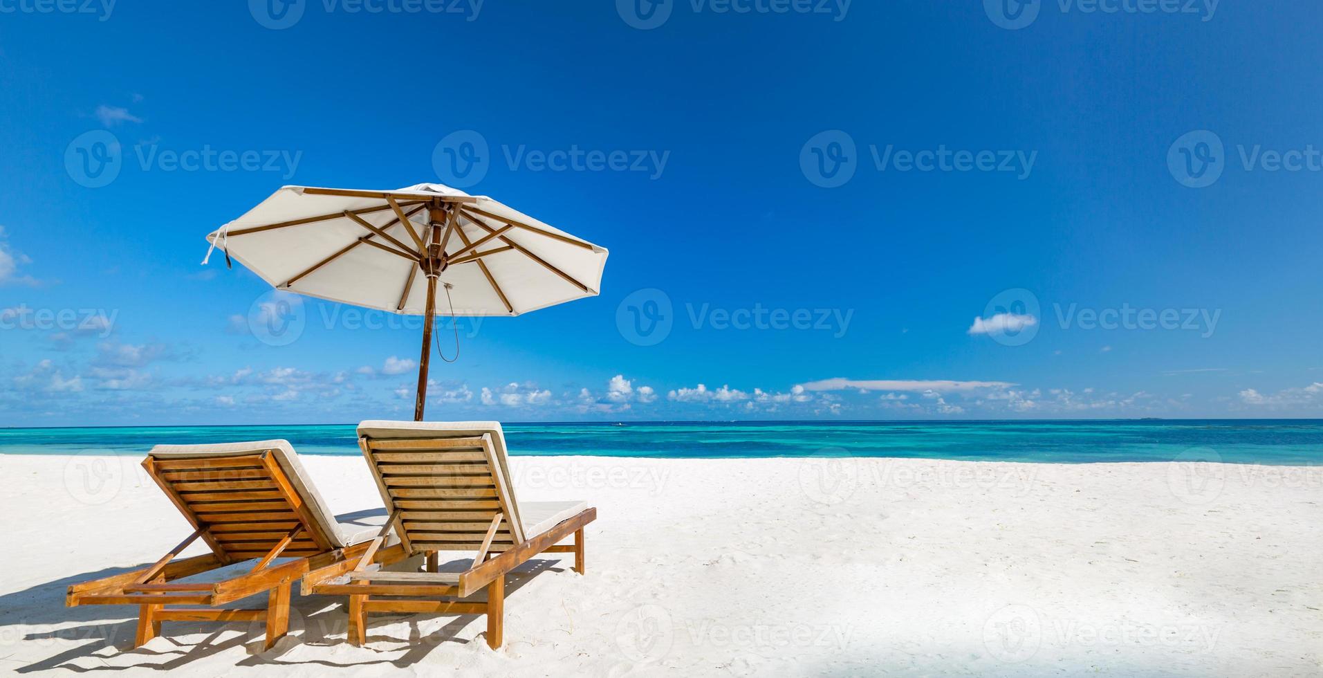 schönes tropisches Strandbanner. weißer Sand und Kokospalmen und Strandkörbe als breites Panorama-Hintergrundkonzept. erstaunliche strandlandschaft, romantische szene für paar- oder flitterwochenreiseziele foto