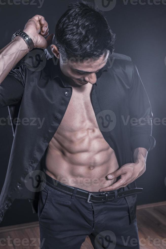 hübsches arabisches männliches Model mit perfektem Körper posiert im Studio. Porträt eines athletischen männlichen Modells, das auf dunklem Hintergrund im Studio posiert. Modekonzept. foto