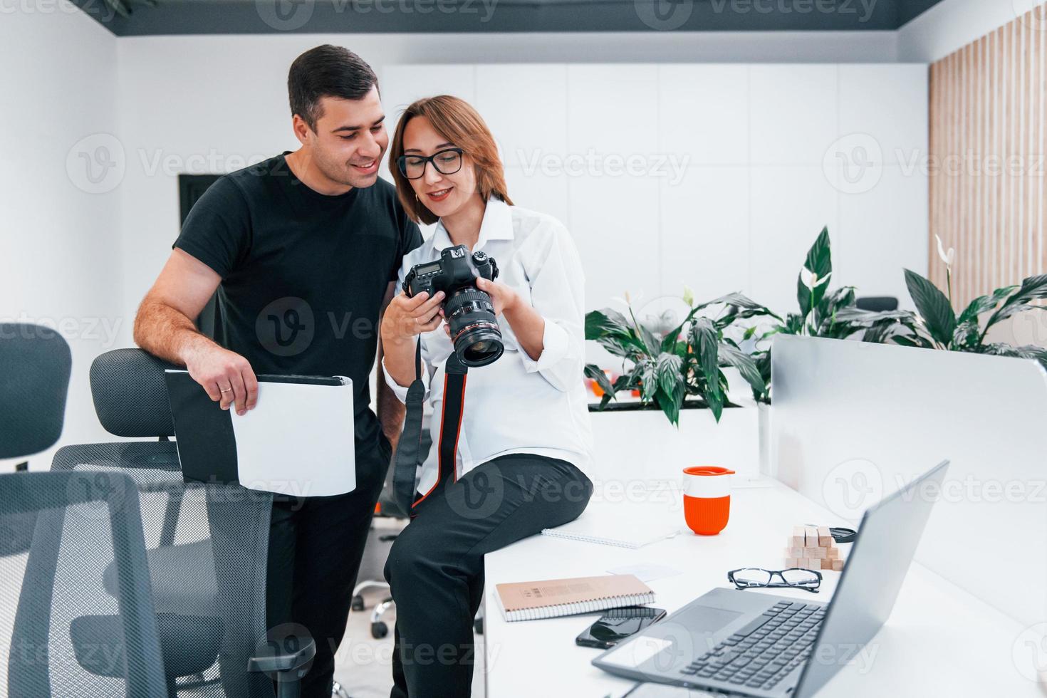 Mann in schwarzer Kleidung, der Fotos auf der Fotografenkamera der Frau anschaut