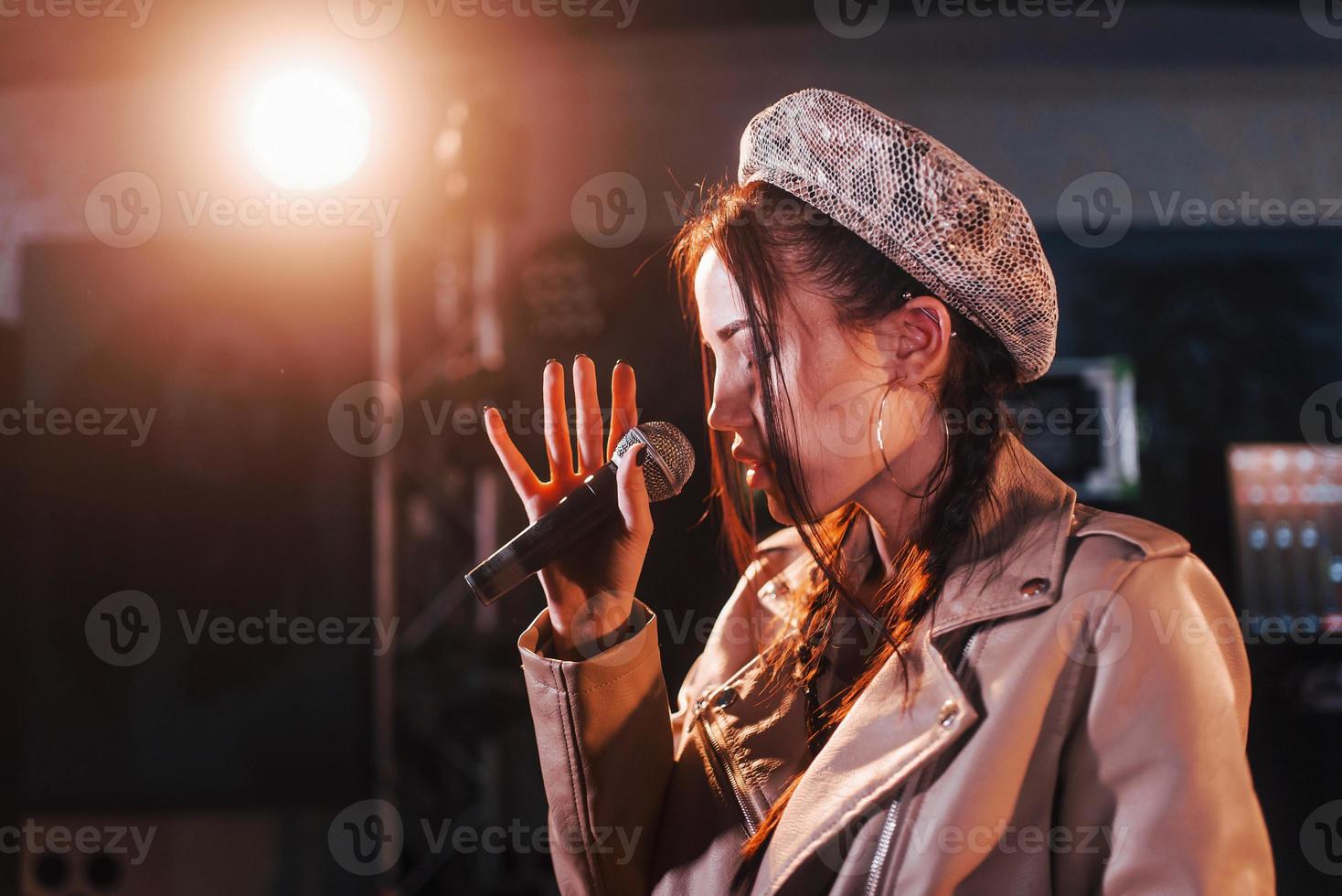 junge schöne Sängerin probt in einem Tonstudio foto