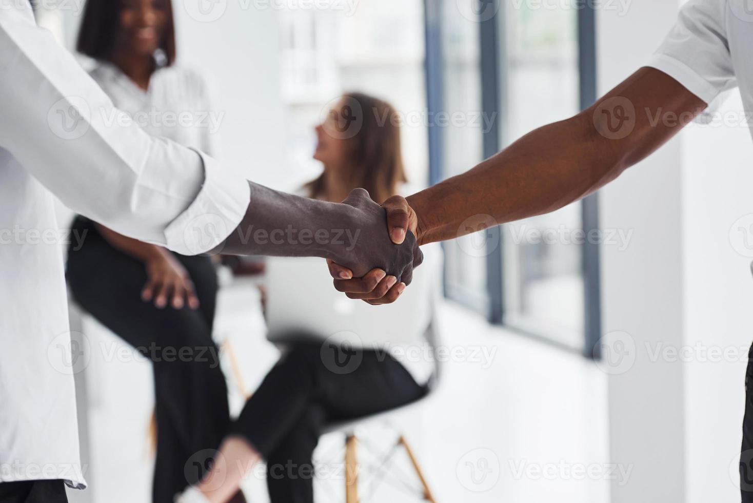 Handschlag machen. erfolgreicher Deal. gruppe afroamerikanischer geschäftsleute, die gemeinsam im büro arbeiten foto