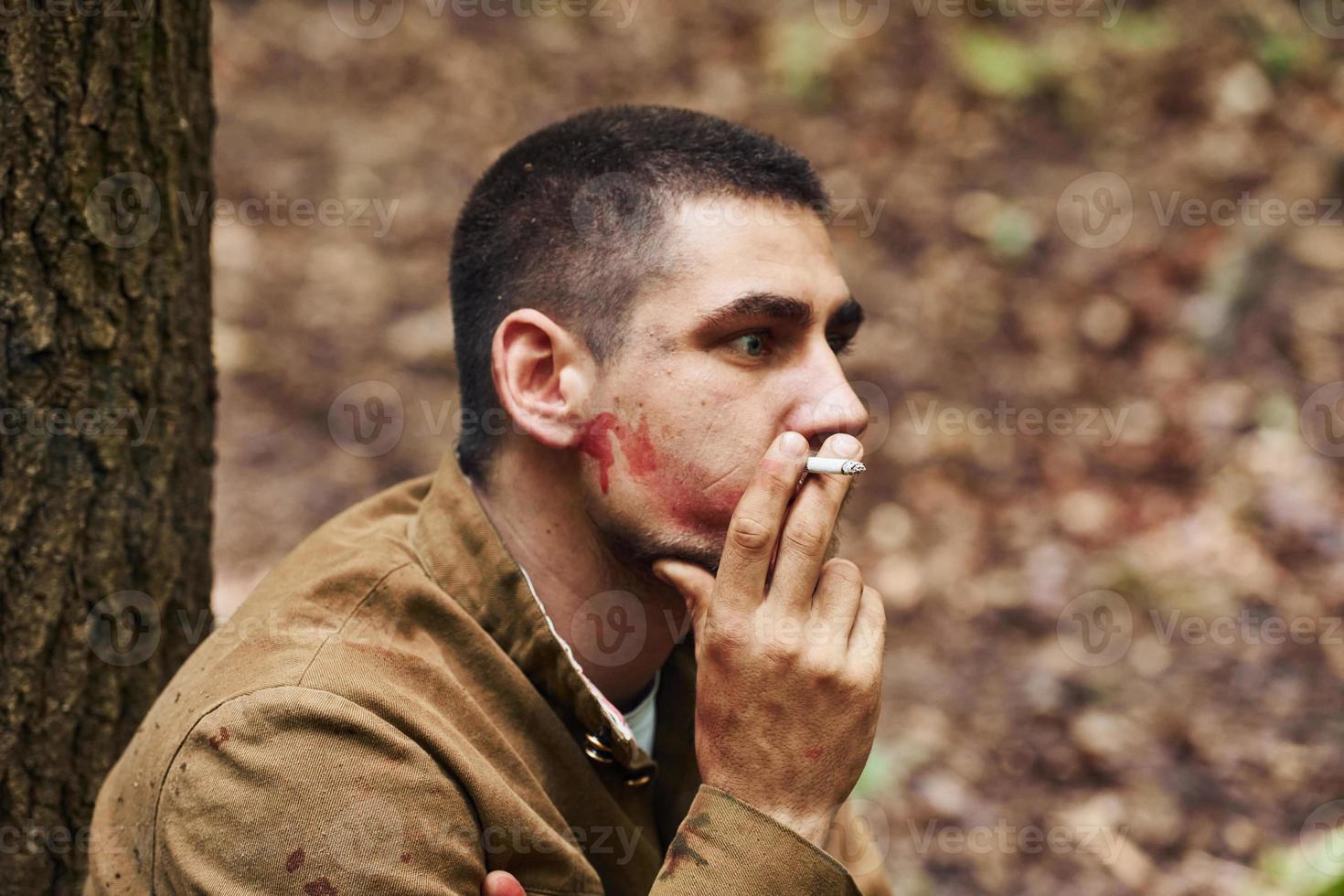 ternopil, ukraine - juni 2020 upa ukrainian aufständische armee filmdreharbeiten. Bilder von hinter der Bühne. Soldat sitzt im Wald und raucht foto