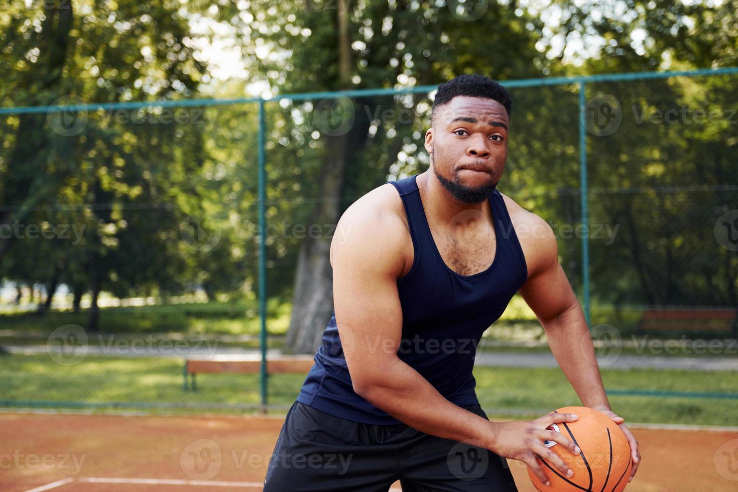 afroamerikaner spielt basketball auf dem platz im freien foto