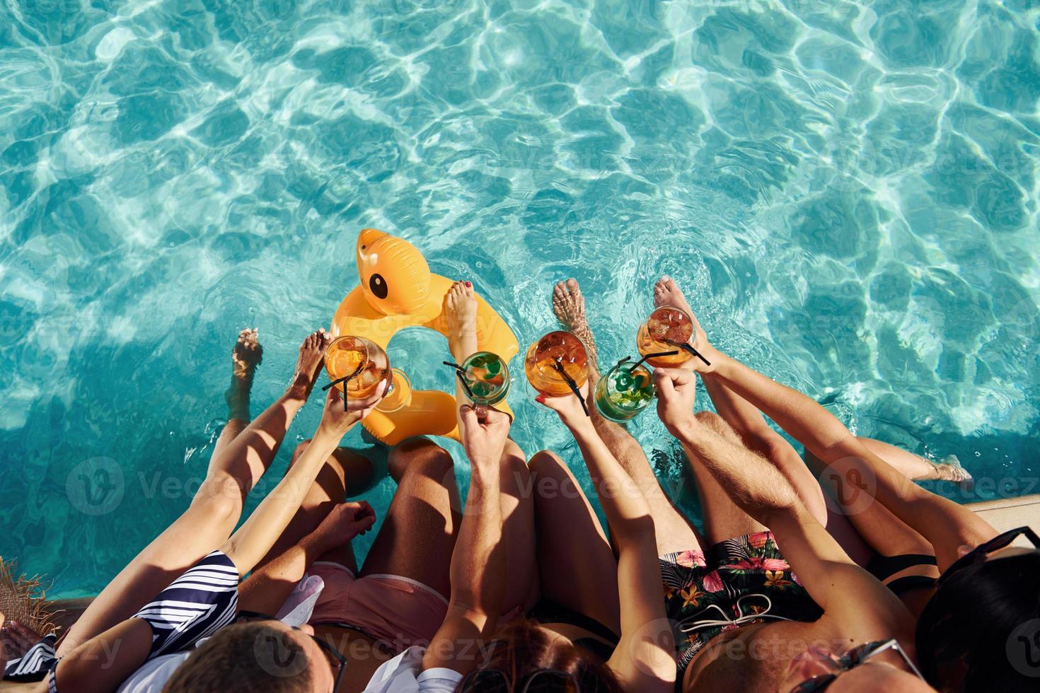 Draufsicht auf eine Gruppe junger glücklicher Menschen, die tagsüber Spaß im Schwimmbad haben foto