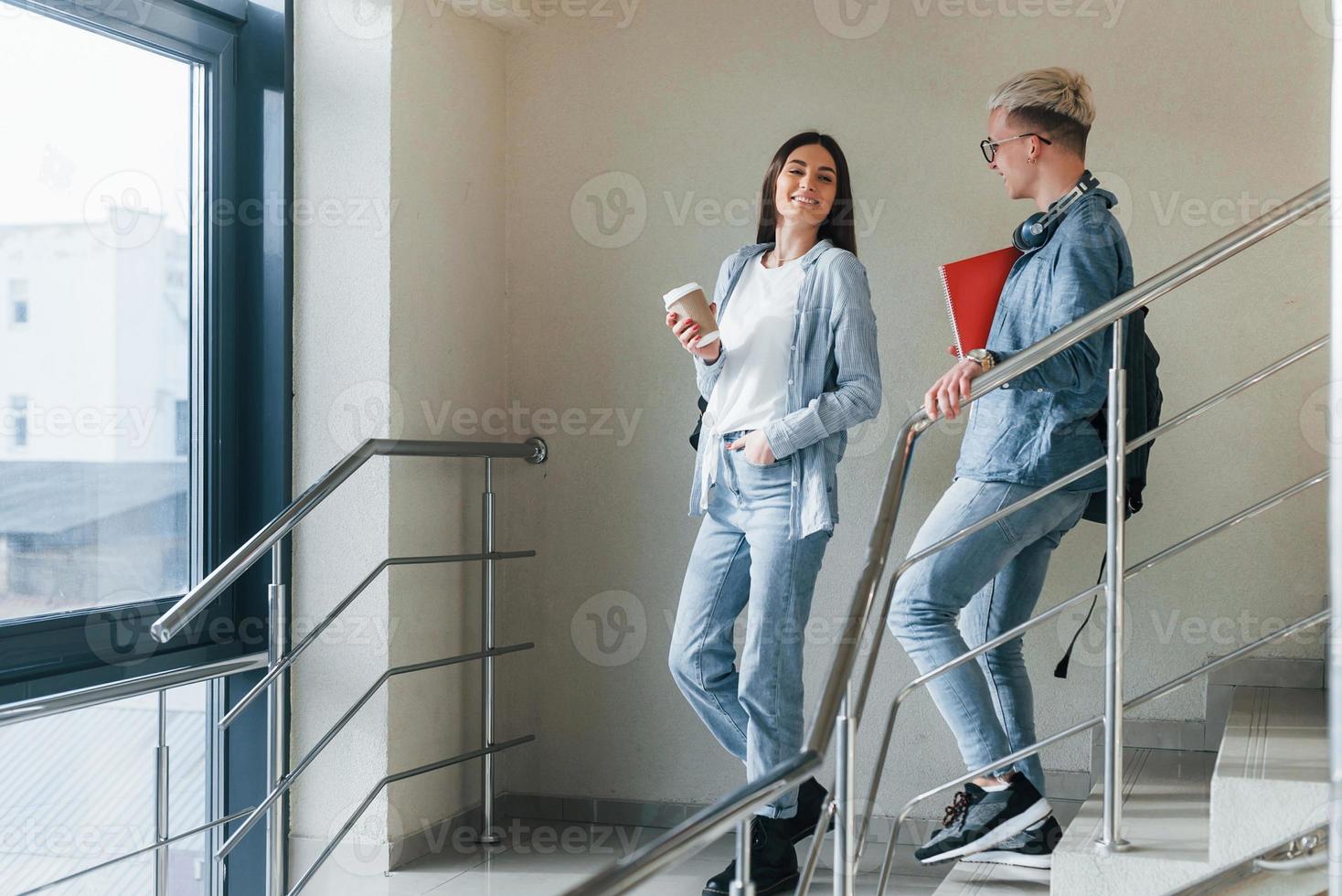 Zwei junge Studentenfreunde zusammen auf der Treppe im College foto