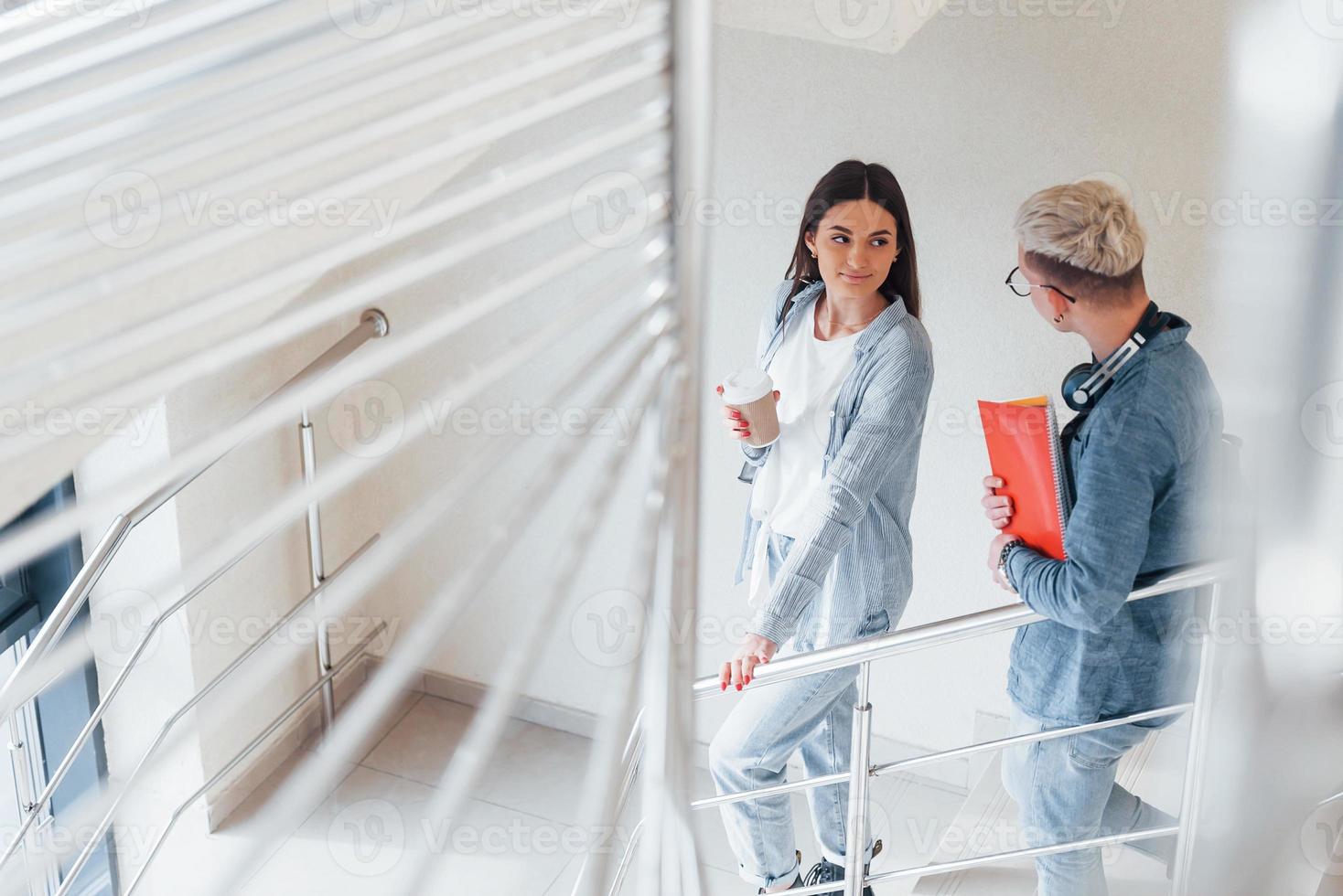 Zwei junge Studentenfreunde zusammen auf der Treppe im College foto