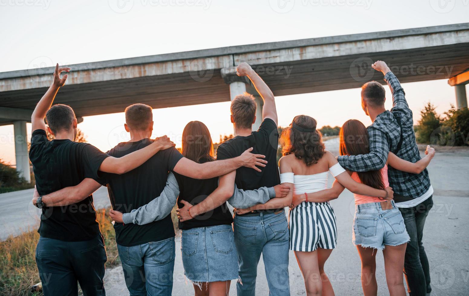 Ansicht von hinten. gruppe junger fröhlicher freunde, die zusammen spaß haben. draußen feiern foto