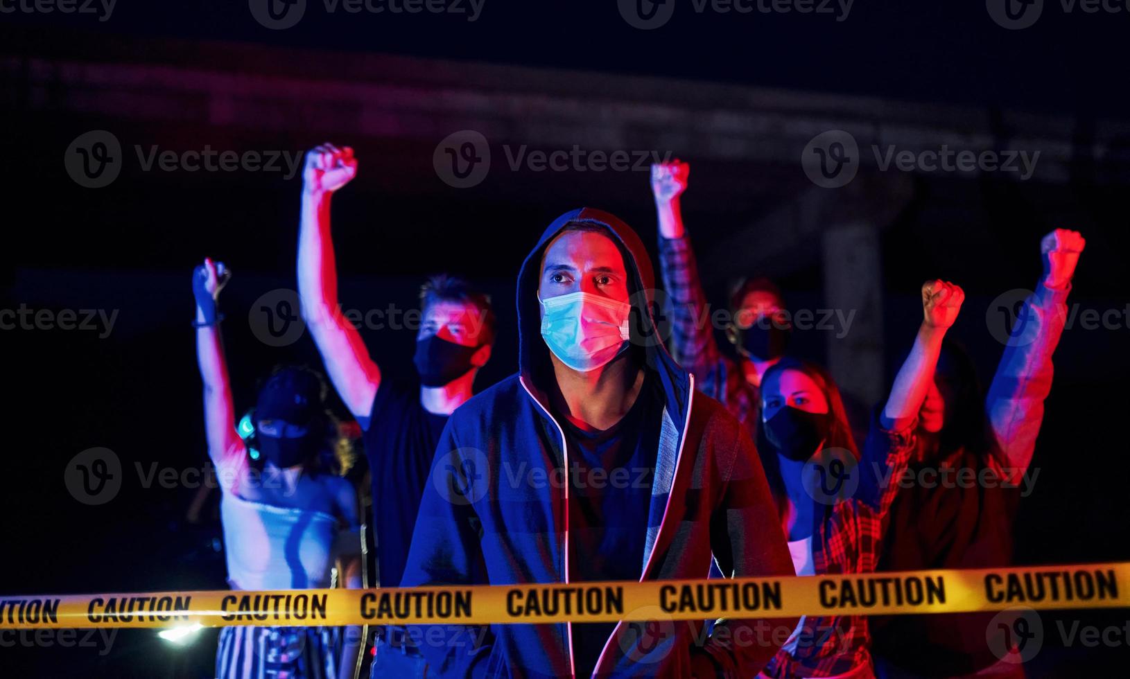 bei Schutzmasken. Gruppe protestierender junger Menschen, die zusammenstehen. Aktivist für Menschenrechte oder gegen die Regierung foto