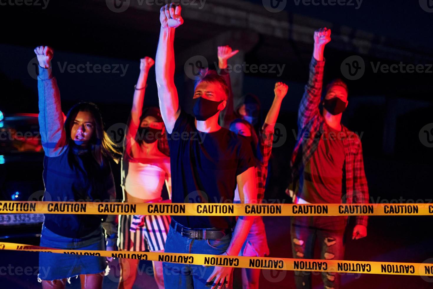 in der Nähe von Polizei-Grenzband. Gruppe protestierender junger Menschen, die zusammenstehen. Aktivist für Menschenrechte oder gegen die Regierung foto