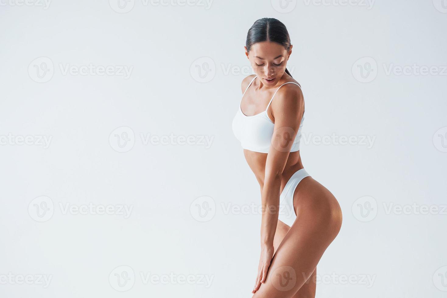 Schöne Frau mit schlankem Körper in Unterwäsche ist im Studio foto