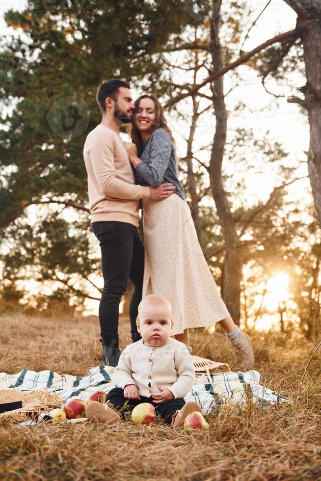 hat Picknick. glückliche familie von mutter, familie und kleinem baby ruht im freien. schöne sonnige herbstnatur foto