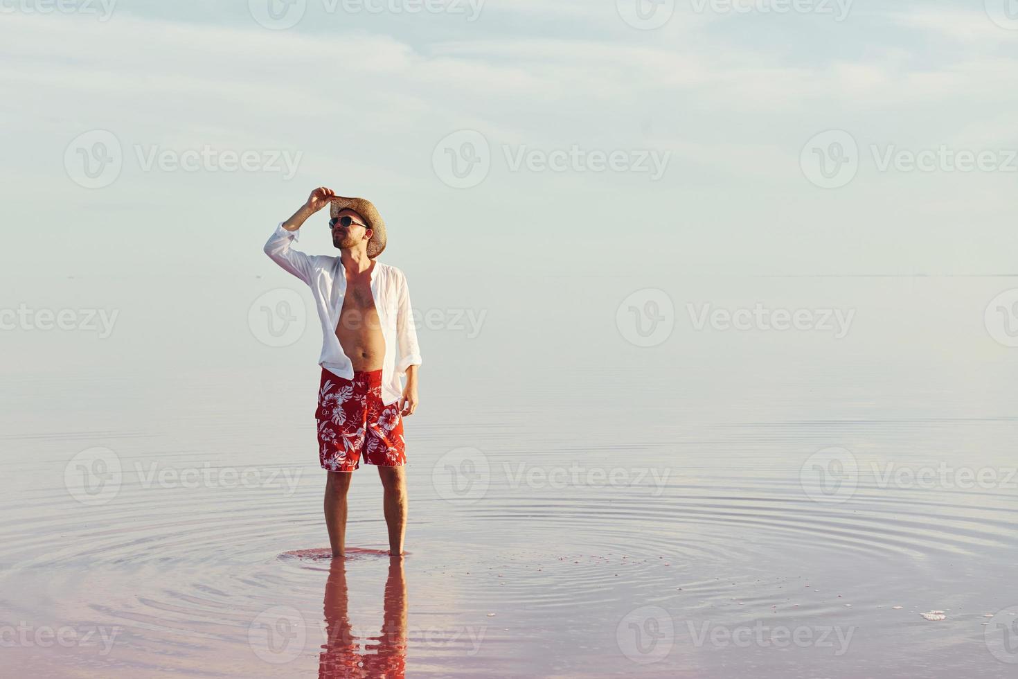 Mann mit Hut und Freizeitkleidung geht auf dem See auf der Insel Jarilgach, Ukraine foto