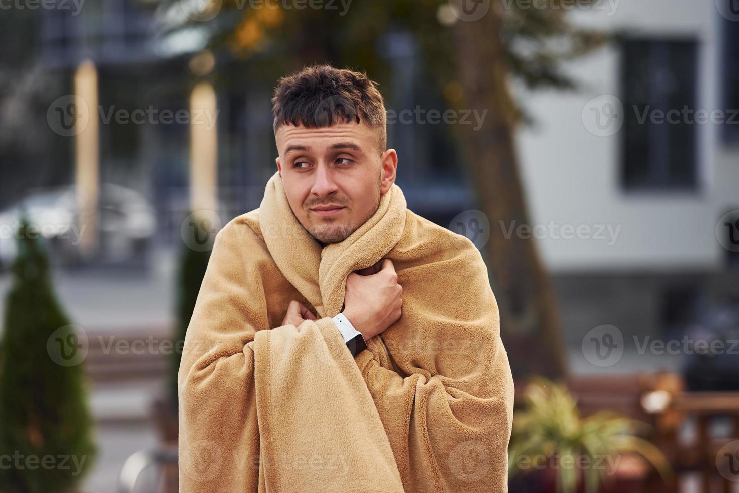 junger mann im pyjama ist draußen auf der straße. fühlt sich schläfrig foto