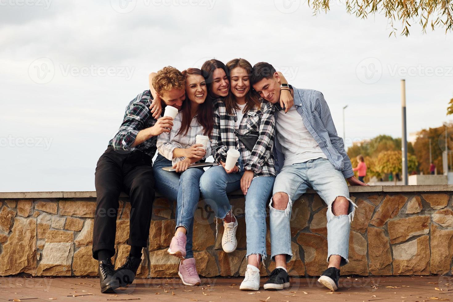 Kaffeezeit. Gruppe junger, fröhlicher Freunde, die draußen Spaß haben foto