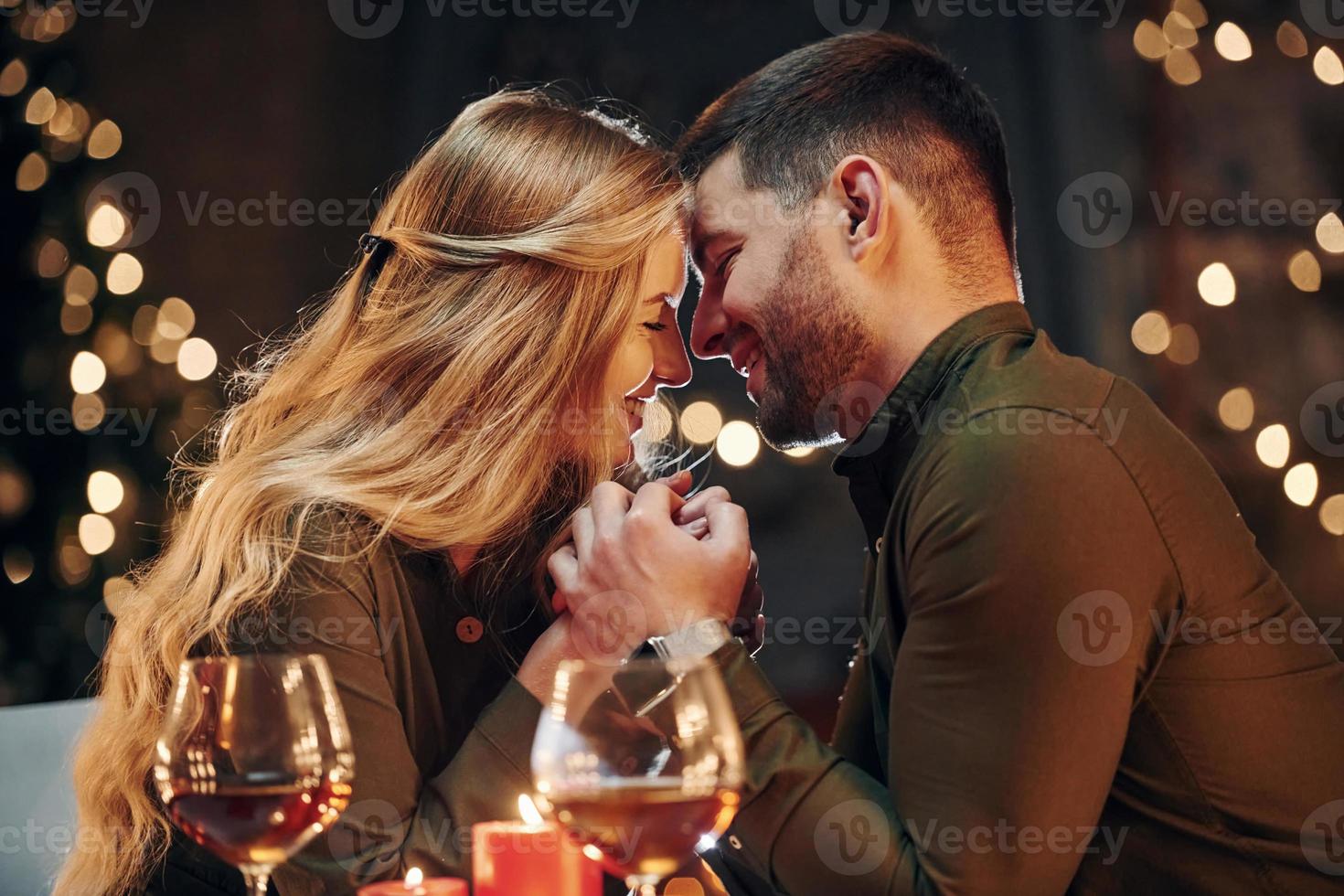 Seitenansicht. junge schöne paare haben zusammen ein romantisches abendessen drinnen foto