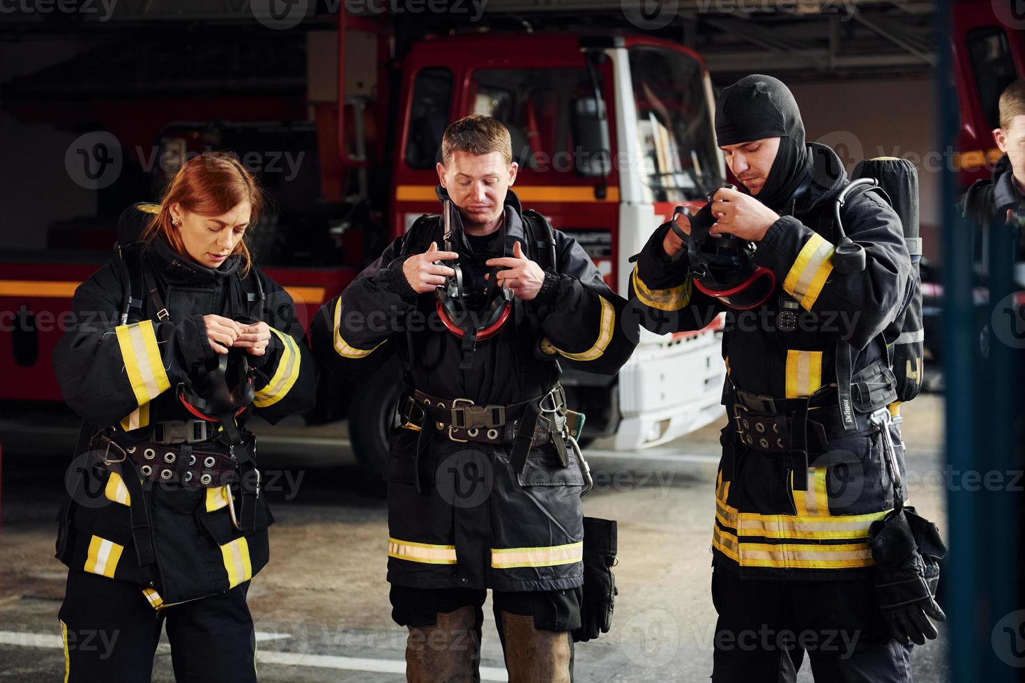 Schutzuniform tragen. Gruppe von Feuerwehrleuten, die auf Station ist foto