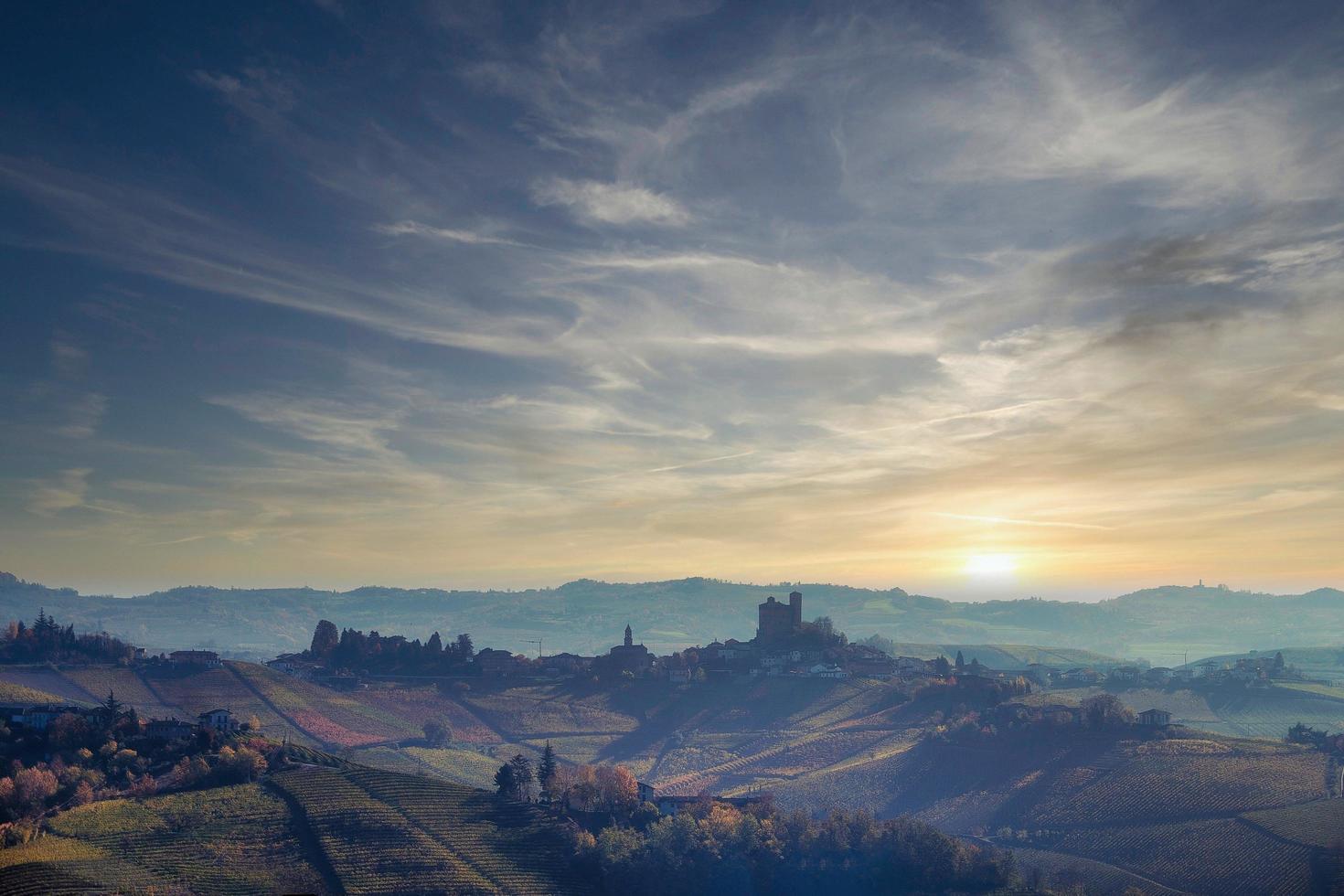 landschaften der piemontesischen langhe mit der berühmten mittelalterlichen burg von serralunga d'alba, mit den leuchtenden farben der herbstsaison foto