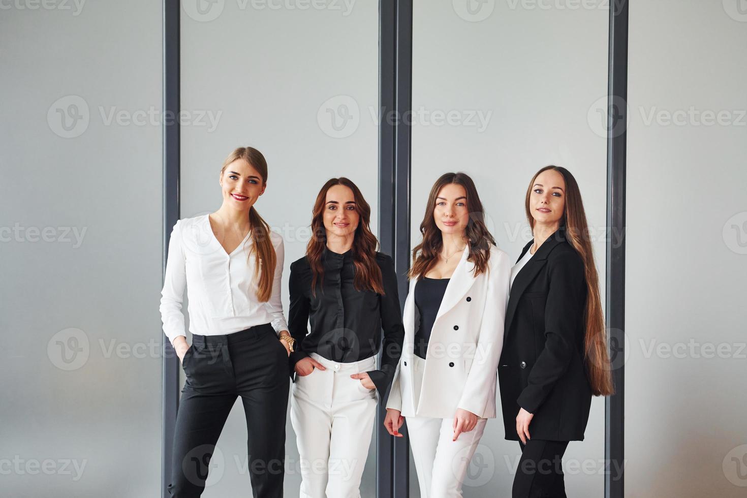 Gruppe erwachsener Frauen, die in formeller Kleidung im Büro zusammen sind foto