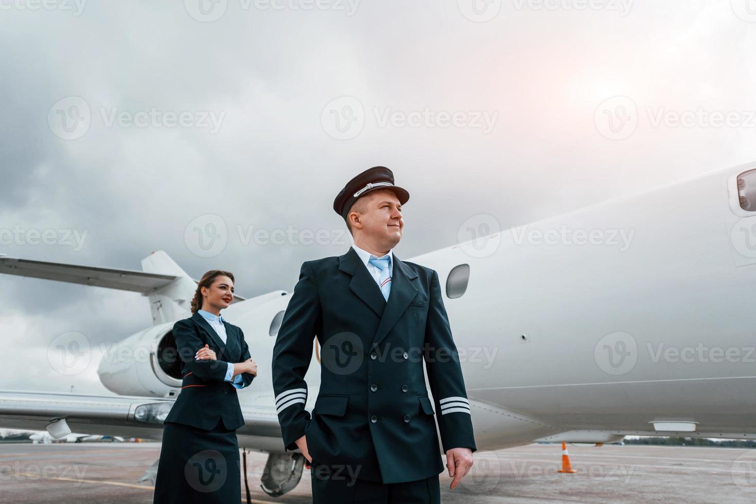 Mann mit Frau. Flugzeugbesatzung in Arbeitsuniform ist zusammen im Freien in der Nähe des Flugzeugs foto