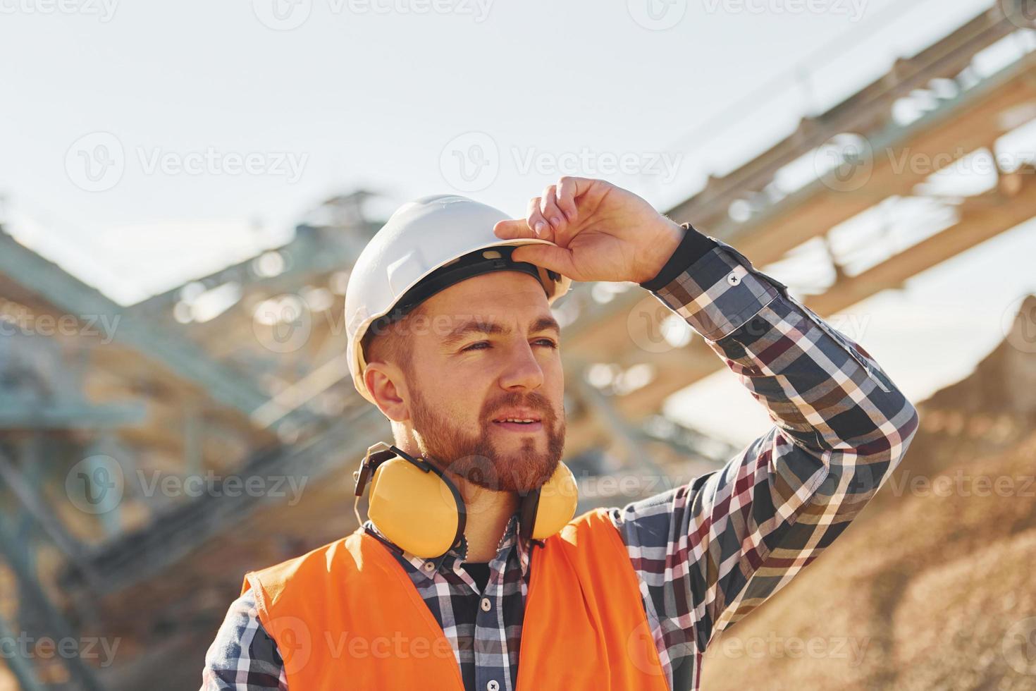 Schwertransport hinter sich. Bauarbeiter in Uniform ist auf dem Steinbruch foto