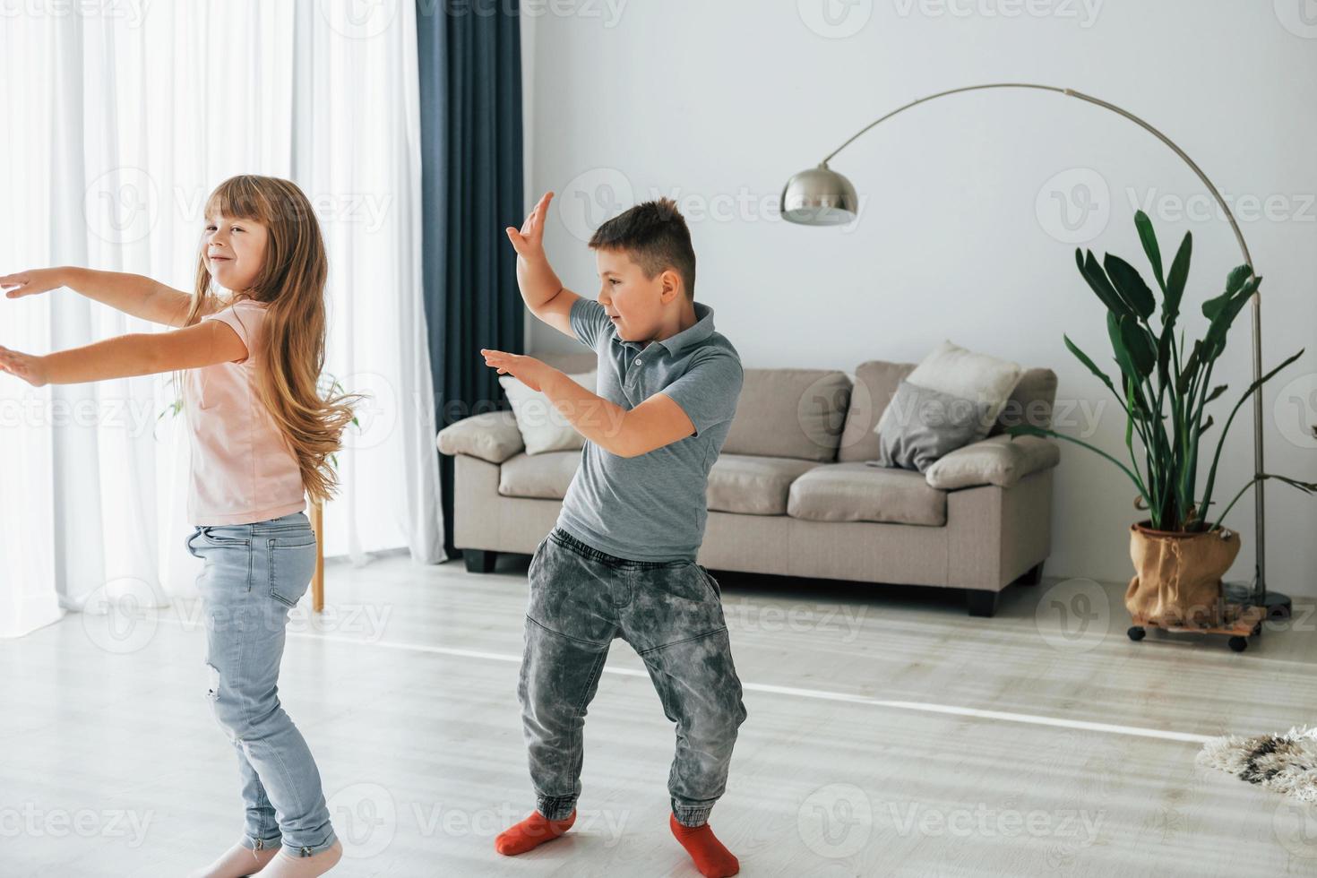 aktive Zeitverbringung am Wochenende. Kinder, die sich tagsüber gemeinsam im Wohnzimmer amüsieren foto