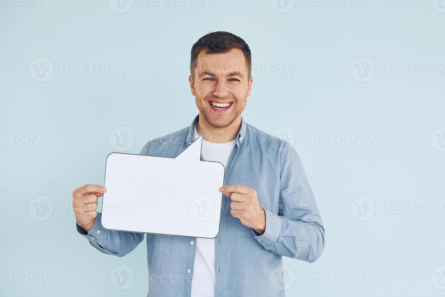 lächeln und gute Laune haben. mann, der im studio mit leeren zeichen für den text steht foto