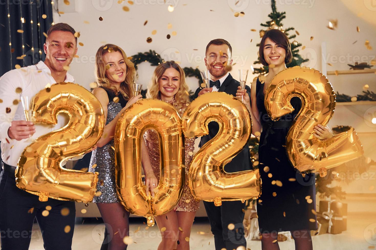 2022 Jahr. eine gruppe von menschen feiert zusammen eine neujahrsparty im innenbereich foto