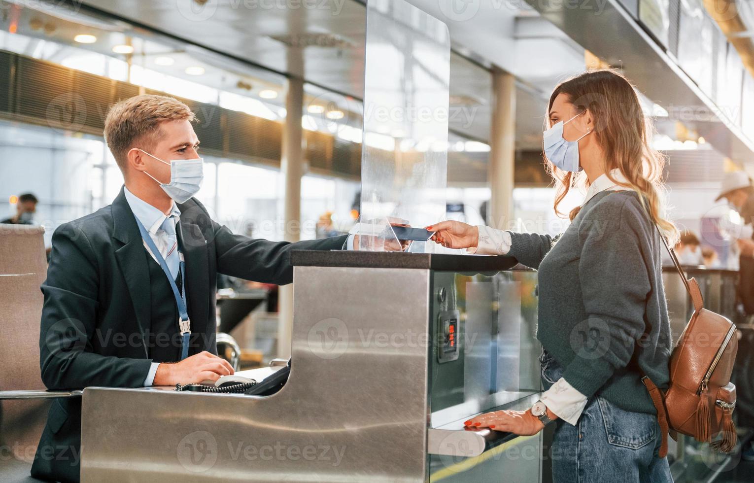 Hilfe von Arbeiter erhalten. junge weibliche touristin ist tagsüber am flughafen foto