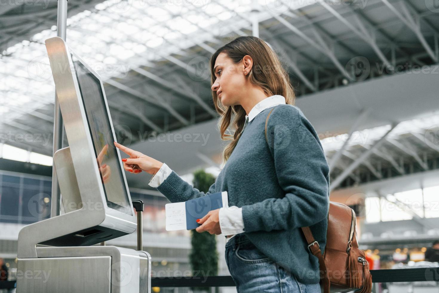 Terminal verwenden. junge weibliche touristin ist tagsüber am flughafen foto