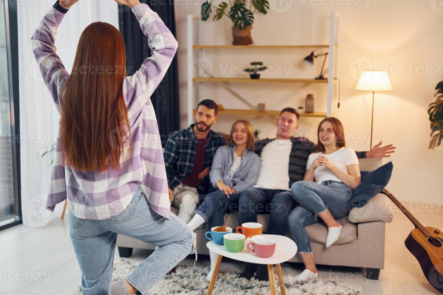 Spiel mit Körpersprache und Posen spielen. gruppe von freunden feiern zusammen drinnen foto