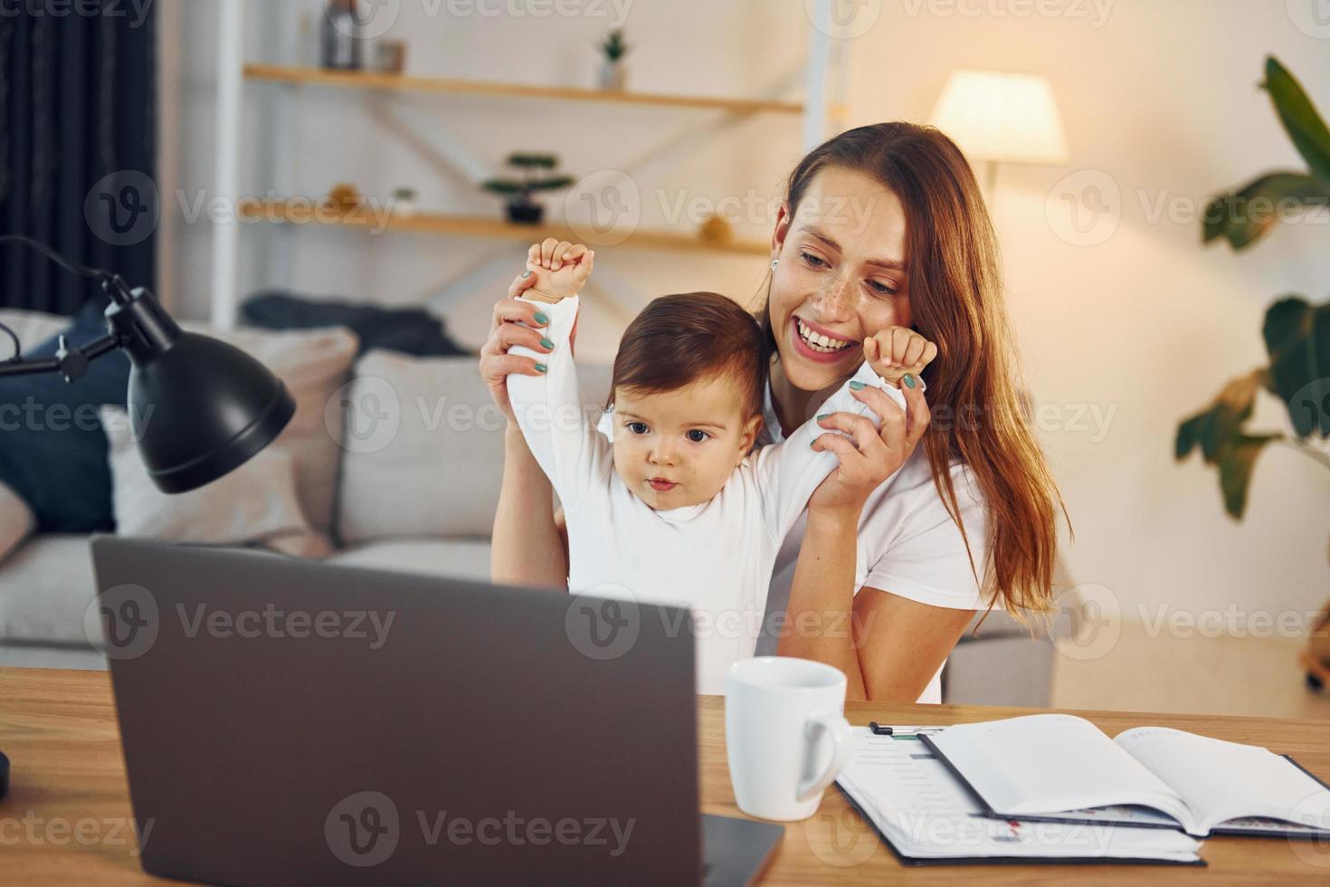 Film ansehen mit Laptop. Mutter mit ihrer kleinen Tochter ist zusammen zu Hause foto