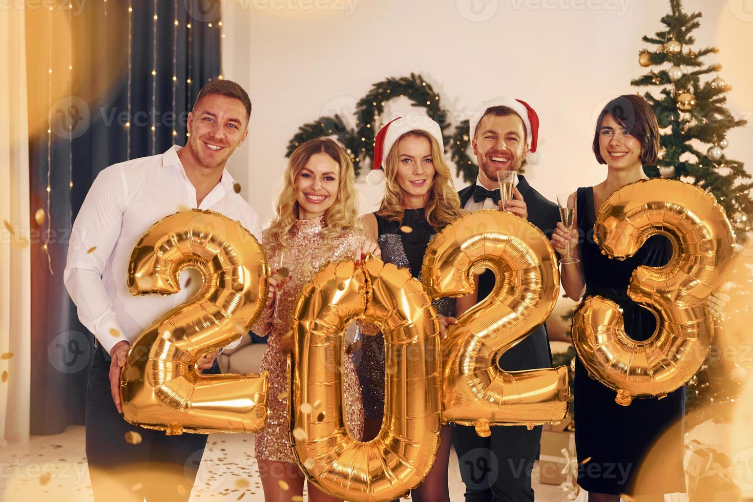2023 kommt. eine gruppe von menschen feiert zusammen eine neujahrsparty im innenbereich foto
