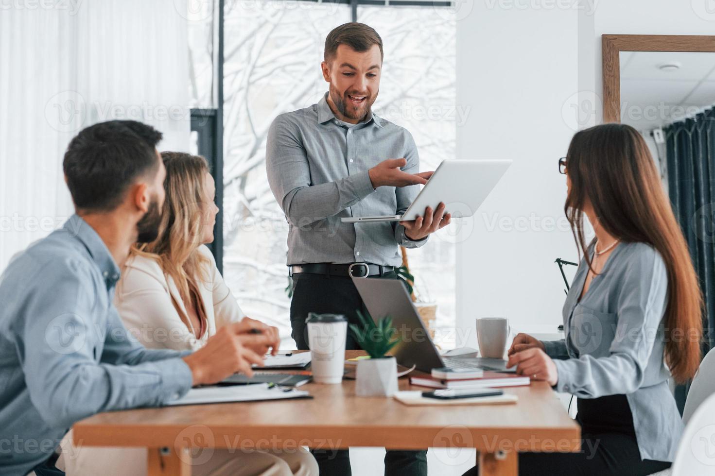 aktives Gespräch. Gruppe von Geschäftsleuten, die im Büro an dem Projekt arbeiten foto