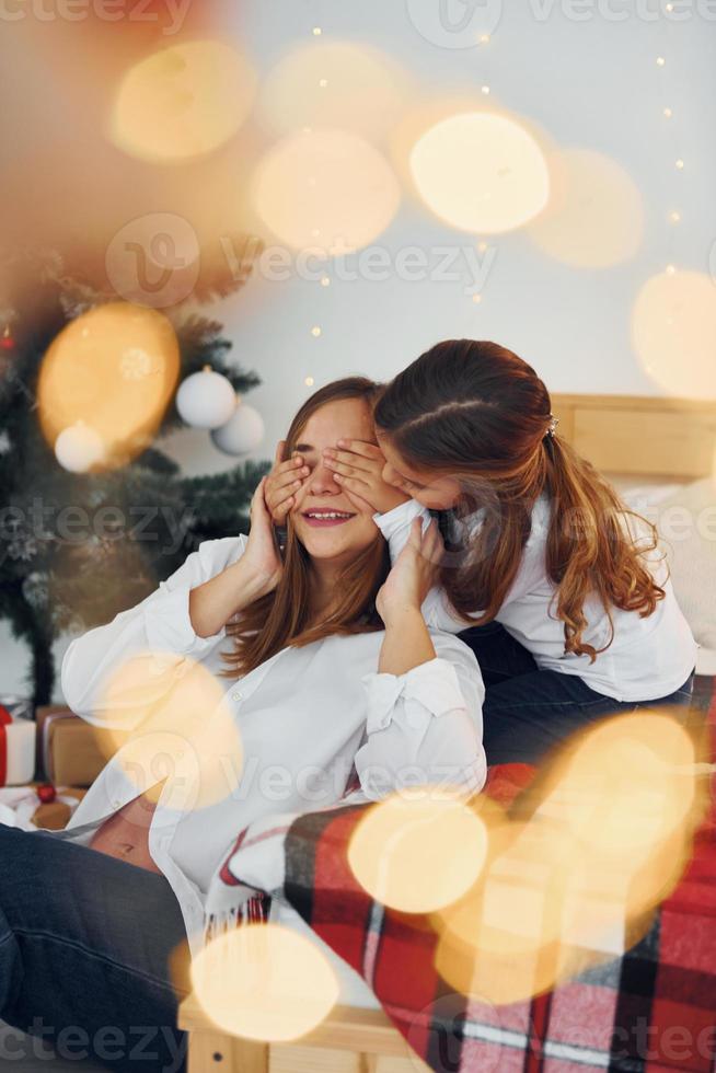 Spaß haben. mutter mit ihrer kleinen tochter hat spaß drinnen auf dem bett foto