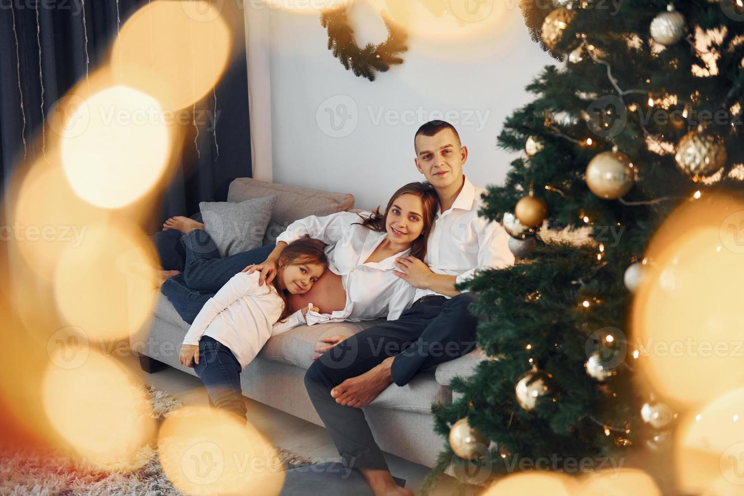 mit Weihnachtsbaum. glückliche familie, die zusammen feiertage drinnen feiert foto