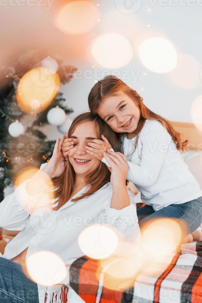 mutter mit ihrer kleinen tochter hat spaß drinnen auf dem bett foto