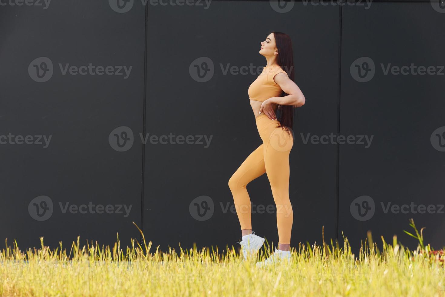 grünes Gras. junge Frau in Sportbekleidung hat eine Fitness-Session im Freien foto