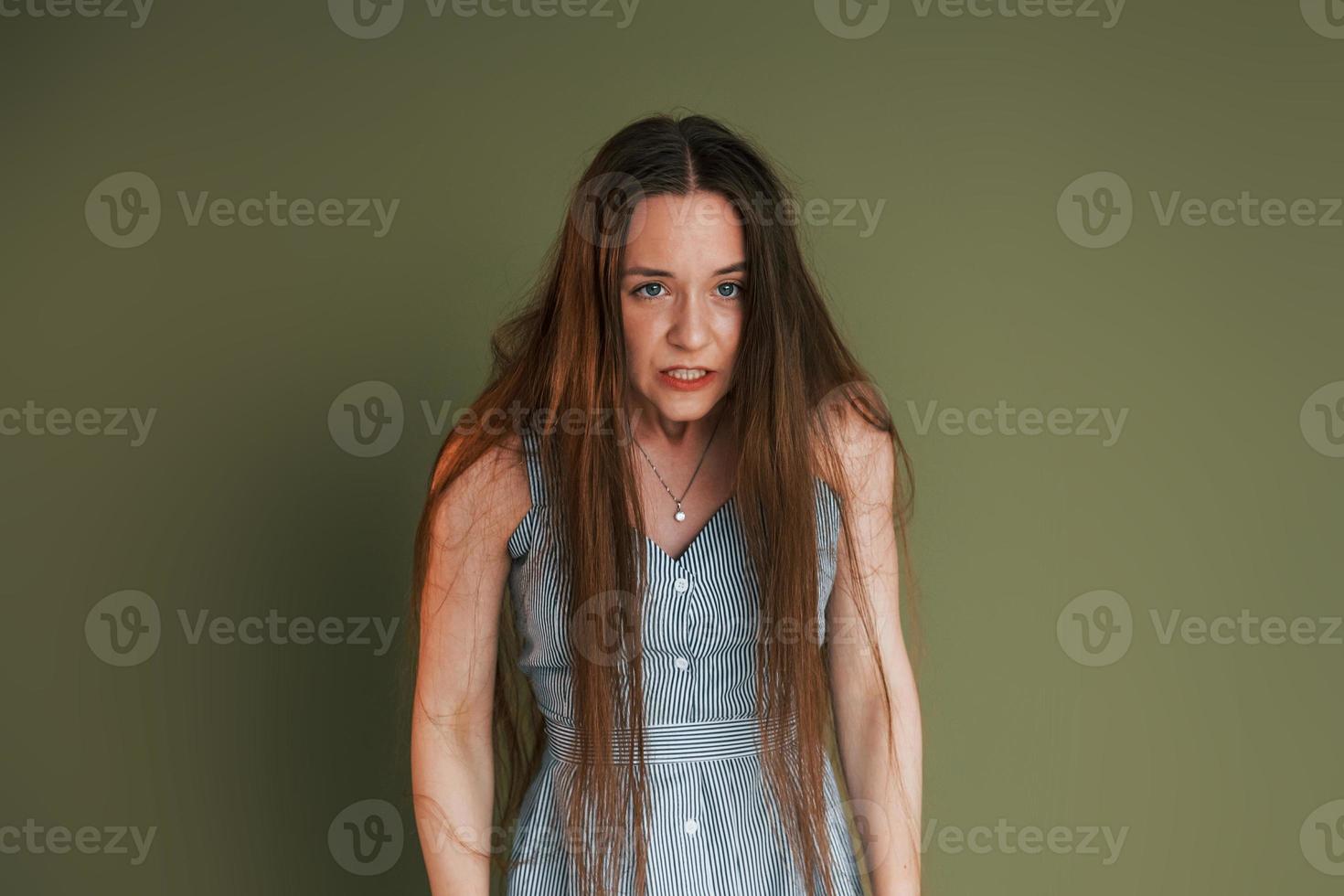 Demonstration von Emotionen. junge Frau in Freizeitkleidung, die drinnen im Studio steht foto