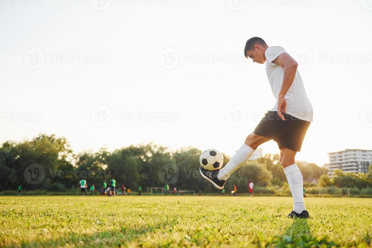 verschiedene Tricks machen. junge Fußballspieler trainieren auf dem sportlichen Feld foto