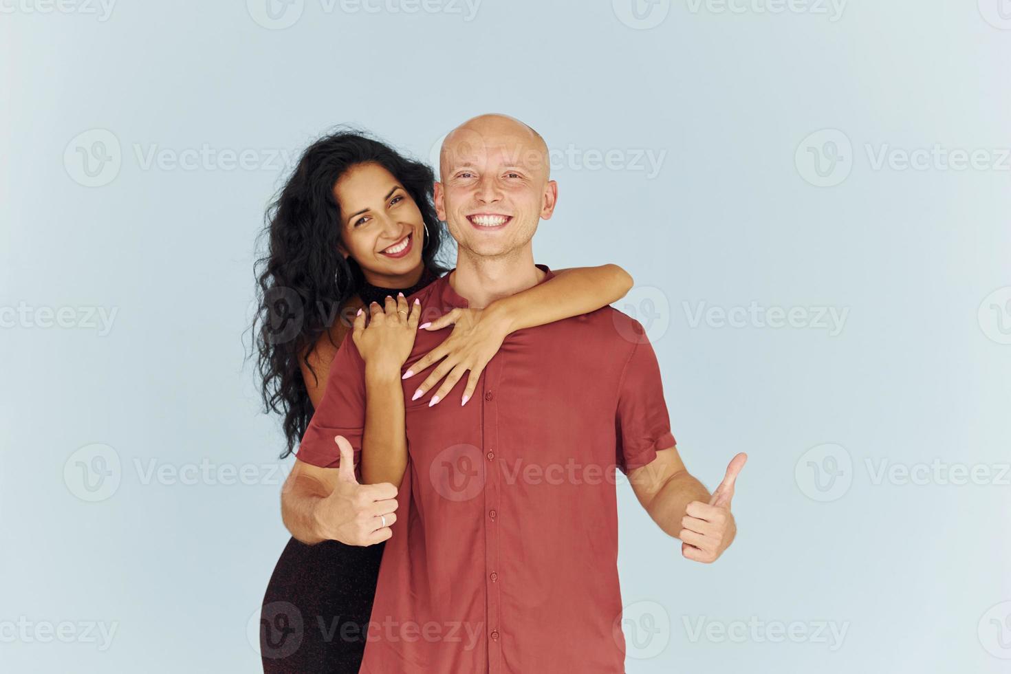 Stehen im Studio vor weißem Hintergrund. Fröhliches Paar ist drinnen zusammen foto