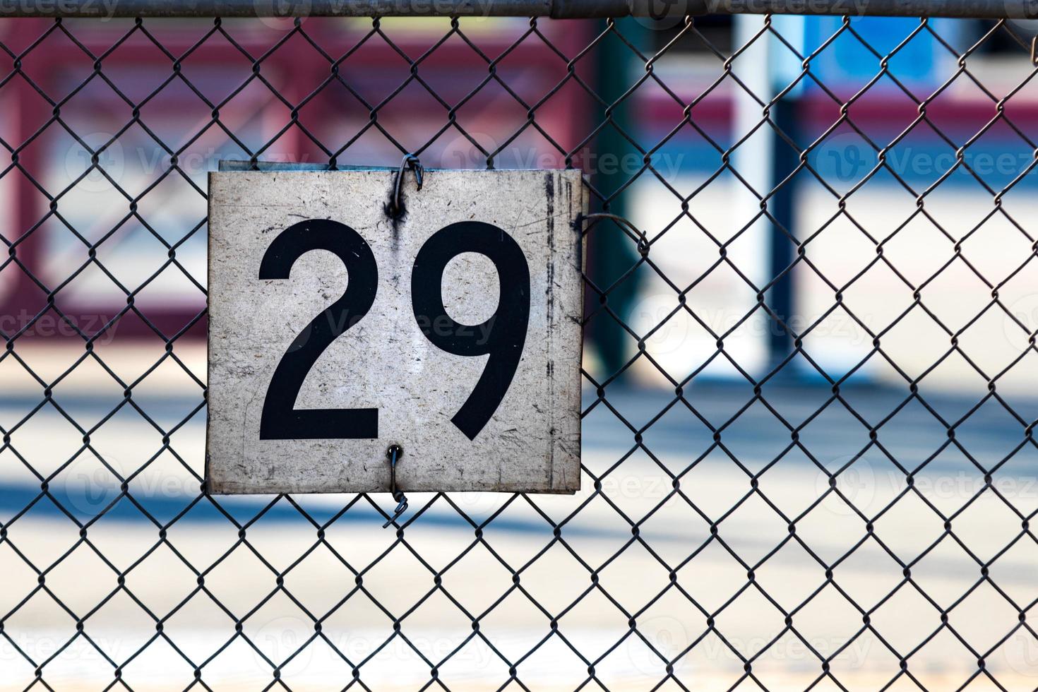 weißes Schild an einem Maschendrahtzaun mit der Nummer 29 foto