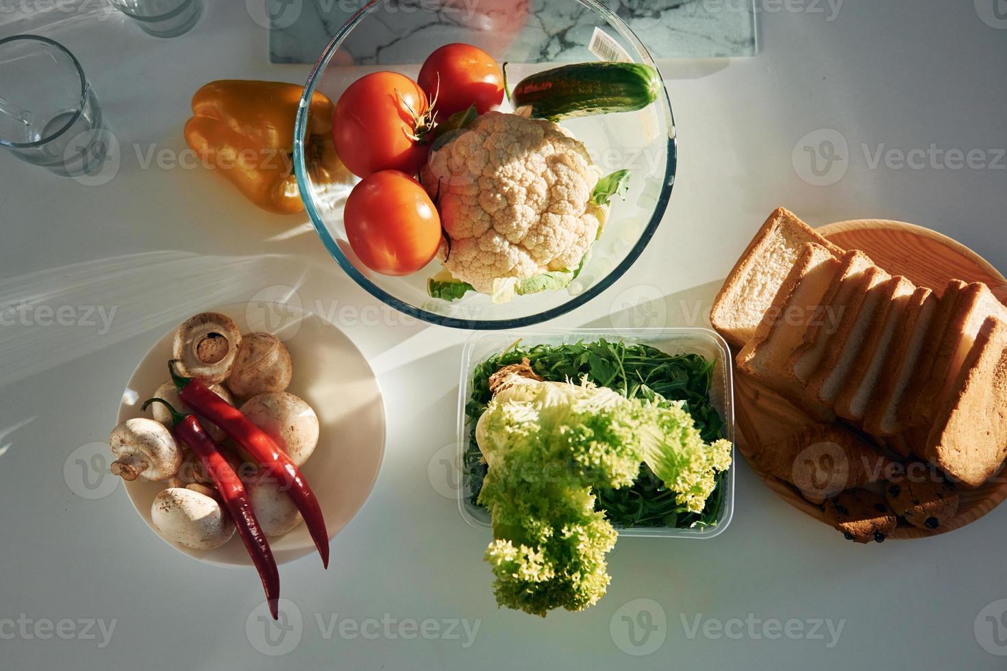 Draufsicht auf Gemüse, das auf dem Tisch liegt. Tomaten, Paprika, Pilze und Brot foto