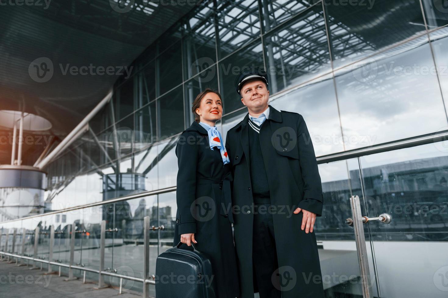 Mann mit Frau. Flugzeugbesatzung in Arbeitsuniform ist draußen auf dem Flughafen zusammen foto